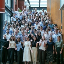 65 new medical interns for 2025 standing on stairs smiling at camera at Austin Health